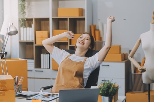 Startup small business entrepreneur or freelance Asian woman using a laptop with box, Young success Asian woman with her hand lift up, online marketing packaging box and delivery, SME concept. photo