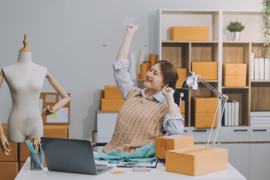 Owners of small online shopping taking a break with her hands behind her head and sitting on a chair in her workshop, relax concept photo