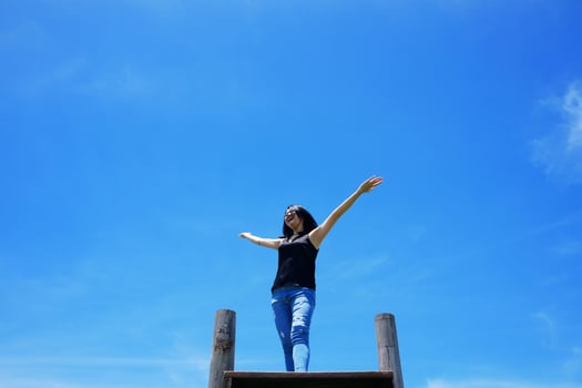 Asian woman Open arms for freedom and happy on the blue sky. Happiness of life is successful and travel in the world. photo
