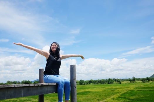 Asian woman sitting on Wooden bridge and open arms for freedom and happy on the blue sky. Happiness of life is successful and travel in the world. photo