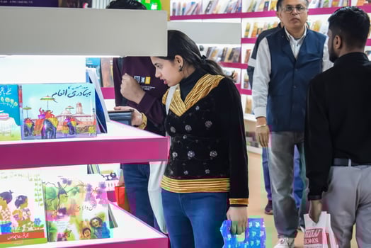 Delhi, India, May 11 2024 - Various age group people reading variety of Books on shelf inside a book-stall at Delhi International Book Fair, Books in Annual Book Fair at Bharat Mandapam complex photo