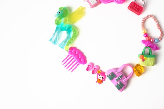 Toys of a little girl in pink tones. Scallops, handbags, horses, beads.Children's wealth. Lined up around on a white background. photo