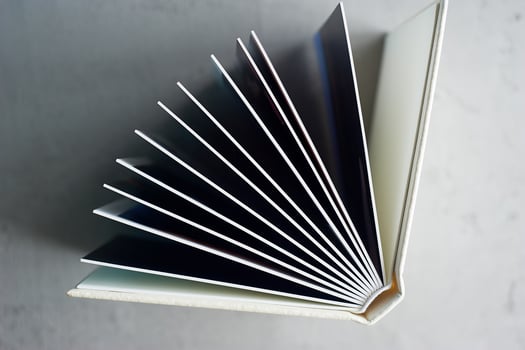 Photobook in hard leather cover on a gray concrete background. Making photos and storing them.A wedding album or book in an expensive binding.