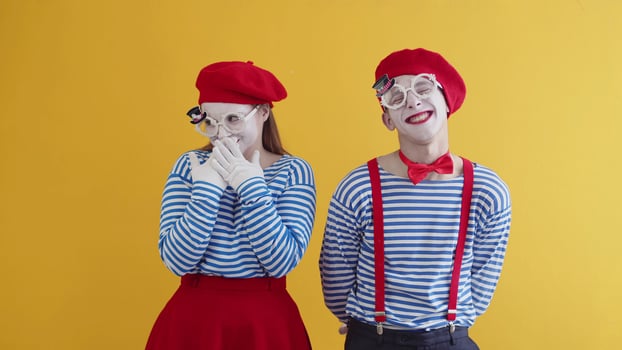 Two Mimes Playing Funny Performance On Yellow Background. A Couple Of Young photo