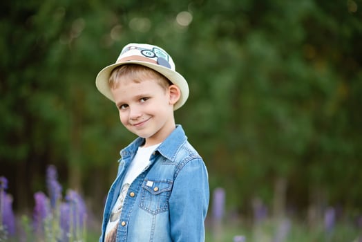 Outdoor portrait of a cute little boy wearing a hat and denim jacket photo