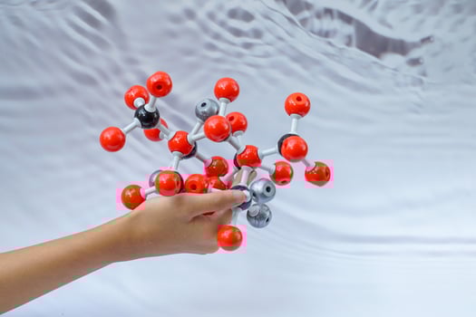Hand holding a Simulate Shape of covalent molecules on a gray and white background. photo