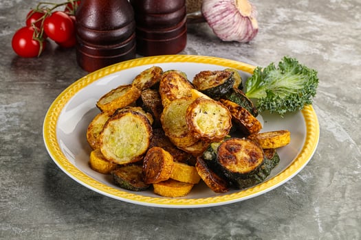 Roasted young zucchini in the plate photo