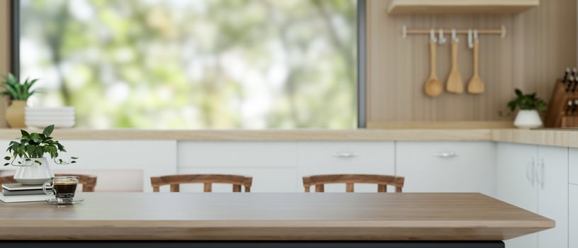 A wooden dining table with copy space for displaying products is in a contemporary kitchen. photo