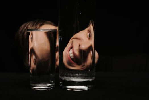 portrait of a smiling man looking through two glasses photo