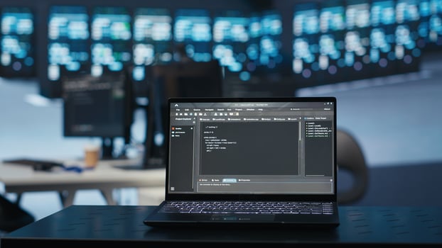 Focus on script running on laptop in server room with man in blurry background safeguarding data from threats. Close up shot of lines of code on notebook written by expert protecting supercomputers photo