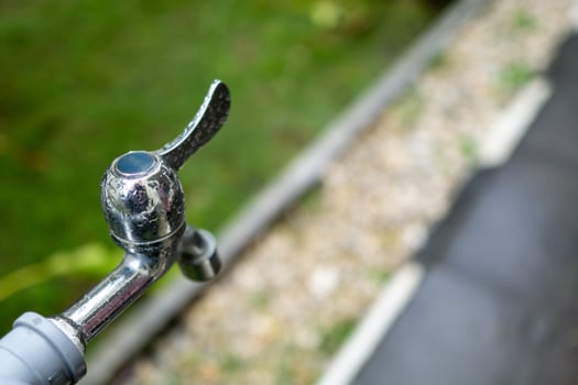 Shower tap water outside the house. Metal faucet in outdoor outlet photo
