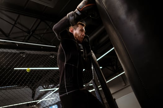 Boxer delivering powerful right hook on heavy bag in gym photo