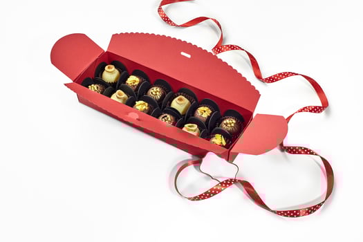 Exquisite chocolate candies in red gift box with dotted ribbon photo