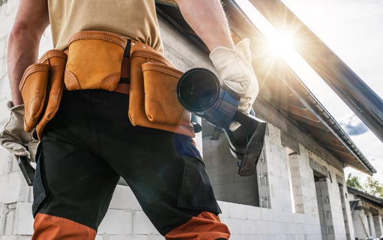 Construction Worker With Tool Belt and Gutter Element in His Hand photo