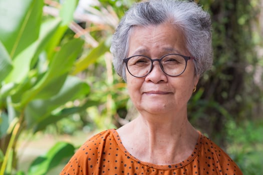 Portrait of a senior woman with short gray hair wearing glasses, smiling and looking at the camera. Space for text. Concept of aged people and relaxation photo