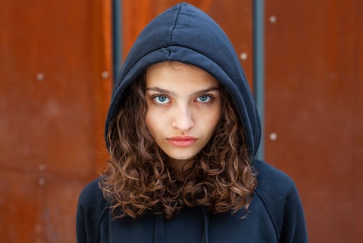 White brunette teenage girl with curly hair poses on the street in the city. photo