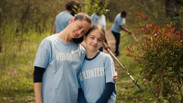 Portrait of mother and daughter volunteering to clean up a forest area, showing a sense of devotion and responsibility for the natural environment conservation. Ecological justice. Camera A. photo