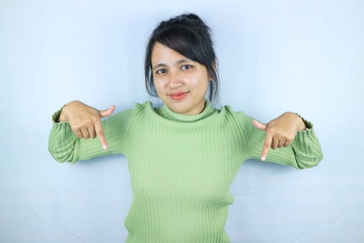Portrait Asian beautiful young woman smiling standing pointing finger out on white background photo