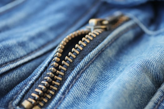 Closeup of metal zipper on denim jeans, photo