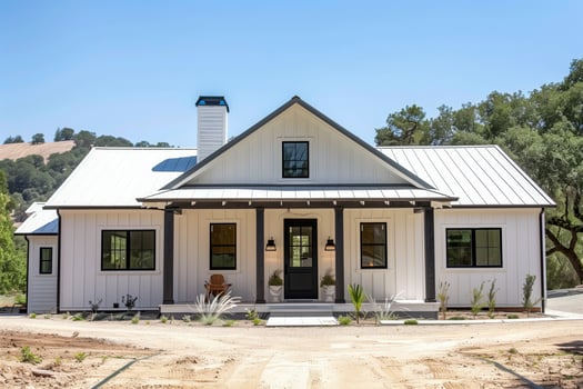 A white house with a black door and a white chimney photo