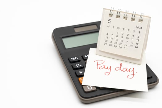 Hand writing text PAY DAY on May 2024 calendar with calculator in isolated background. Reminder concept of payment. copy space. photo