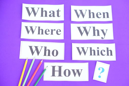 Paper cards with Wh-question words and question marks on purple background. Concept. Teaching aid. Education materials for teach WH- question. Asking questions. Suspicious symbol to find answer. photo