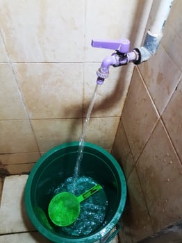 Filling Bucket with Water in Bathroom photo