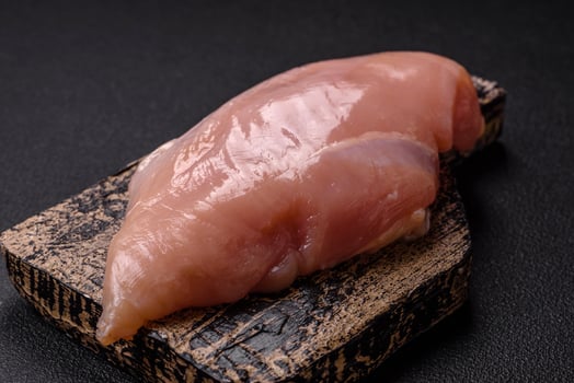 Raw chicken fillet with salt, spices and herbs photo