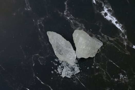 Lumps of alum on a black background. It is a mineral with clear, white crystals, odorless, astringent taste, ground into a white powder that resembles rock sugar.. photo