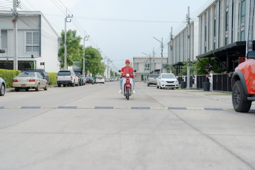 Delivery rider on red motorbike with insulated food box parked outdoors photo