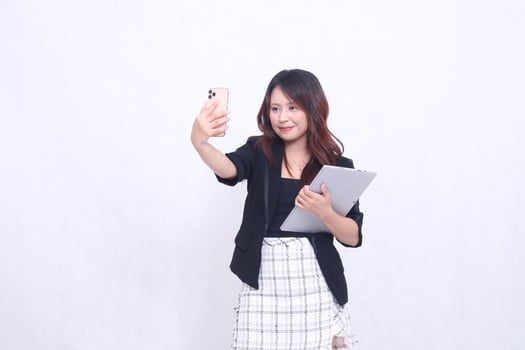 beautiful southeast asian woman 20s formal office flat smile medium in front of camera carrying tablet for promo isolated white background photo