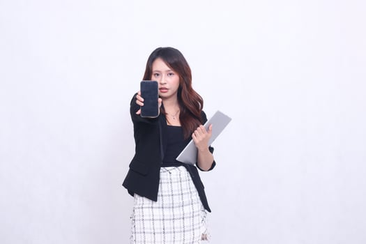 beautiful southeast asian woman 20s formal serious office looking at cell phone gadget screen and carrying tablet for promo isolated white background photo