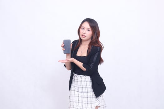 beautiful Indonesian office woman 20s glamorous expression telling cell phone gadget screen cream color hand for promo isolated white background photo
