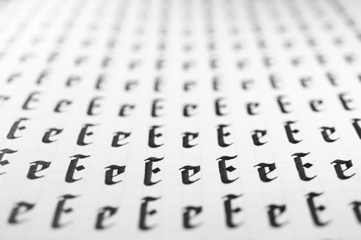 Calligraphy black and white letters E background. Lettering practice writing worksheet. Handwriting symbol filling pattern. Calligraphic letter E learning skills paper page. photo