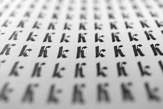 Handwriting black and white symbol filling pattern. Calligraphic letter K learning skills paper page. Calligraphy letters k background. Lettering practice writing worksheet. photo