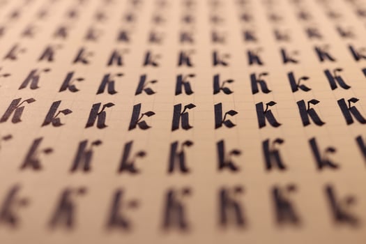 Handwriting symbol filling pattern. Calligraphic letter K learning skills paper page. Calligraphy letters k background. Lettering practice writing worksheet. photo