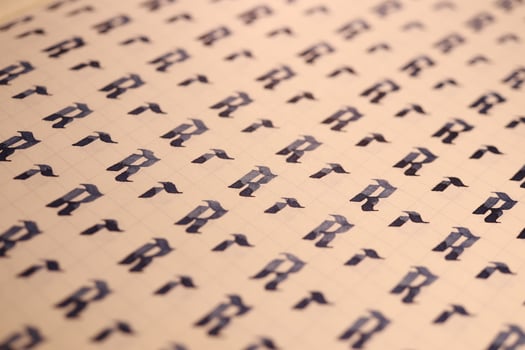 Lettering practice writing worksheet. Handwriting symbol filling pattern. Calligraphic letter R learning skills paper page. Calligraphy letters r background. photo