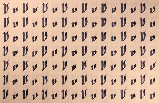Handwriting symbol filling pattern. Calligraphic letter V learning skills paper page. Calligraphy letters v background. Lettering practice writing worksheet. photo