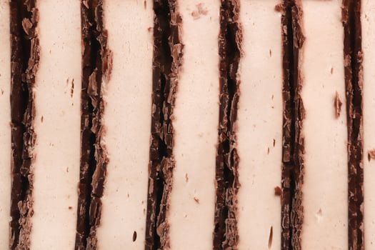 Sliced chocolate with white nougat stripes filling background. Sweet delicious texture. photo