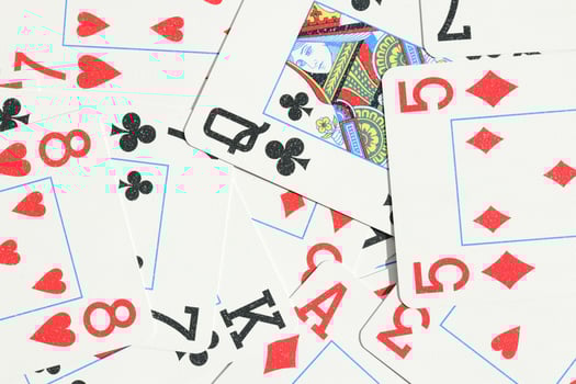 Assorted play cards backdrop. Many miscellaneous jumbled playing cards surface. Mixed playing cards background. photo