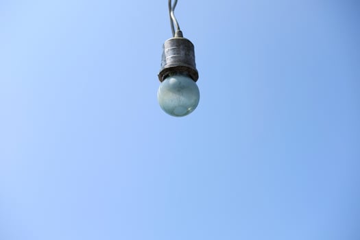 Equipped and electrical with light bulbs is hanging in the wind and sunlight on blue sky photo