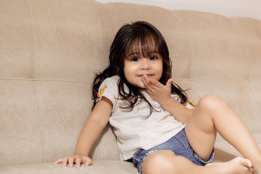 Portrait of cute little girl sitting on sofa. photo