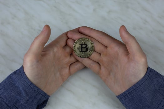 Bitcoin in the hands of man, cryptocurrency coin physical version with a built-in chip with money, expensive coin for investment photo