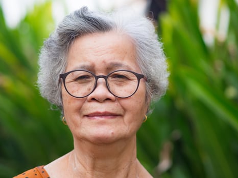 Portrait of an elderly woman looking at camera while standing in a garden photo