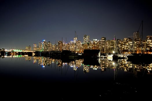 Downtown Vancouver on a winter evening glows in the dusk against a backdrop of majestic mountains photo