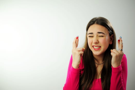 The girl crossed two fingers near her head and is very worried that everything will work out sincere smile beautiful teeth fresh good She has emotionally positive emotions long live natural hair pink photo