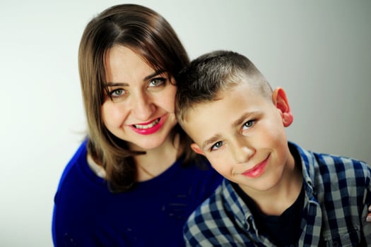Happy mother embracing son in gratitude smiling Happy mother spend time with son, relatives people hugging at home, adult attentive millennial grateful loving mommy caring about her comfort photo