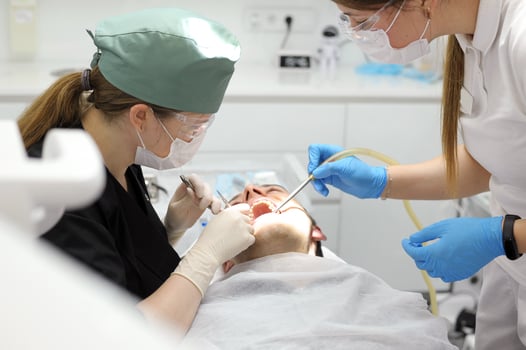 close-up shot of female dentist examining teeth of young happy client photo