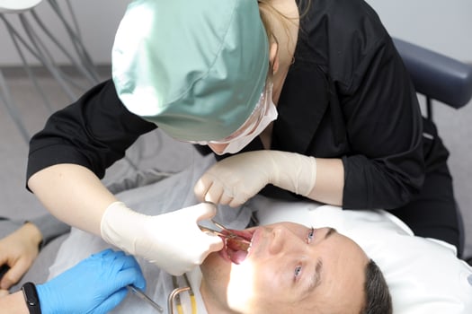 Dentist doctor works with a patient close-up remove teeth photo