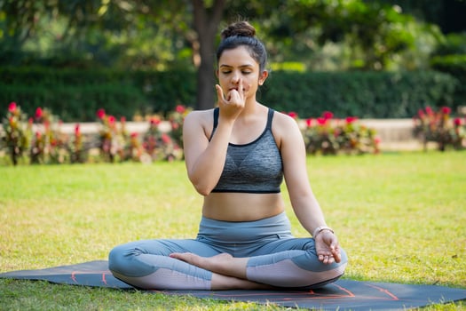 At the Park, An Asian Fit Woman Closes Her Eyes and Doing Breathing Exercise. photo